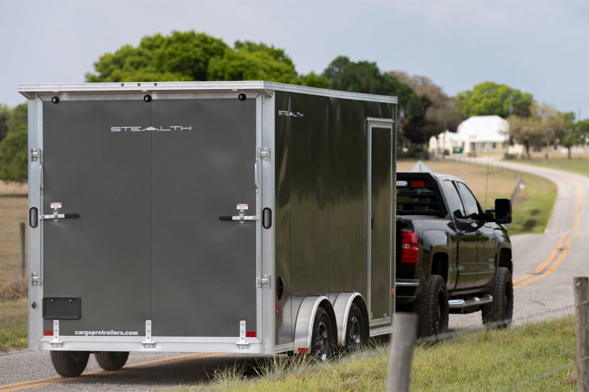 Black Truck Carrying Enclosed 8.5 Wide UTV Trailer On Paved Road