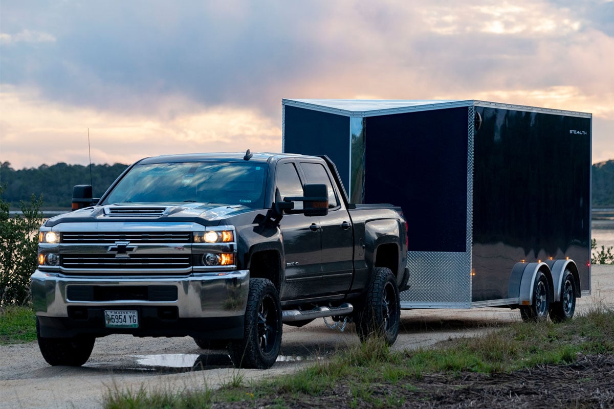 Black Truck Towing Enclosed 7.5 Wide UTV Trailer In Cloudy Weather